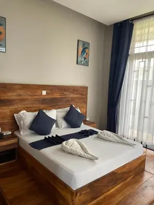 a bedroom with a large bed with blue pillows at Luxurious 2bed in Arusha