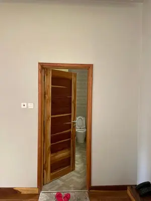 a door to a bathroom with a toilet in a room at Luxurious 2bed in Arusha