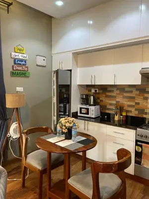 a kitchen with a table and chairs in a kitchen at Luxurious 2bed in Arusha