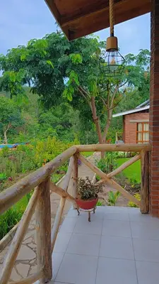 a porch with a potted plant on a wooden railing at Daima Escape in Usa River
