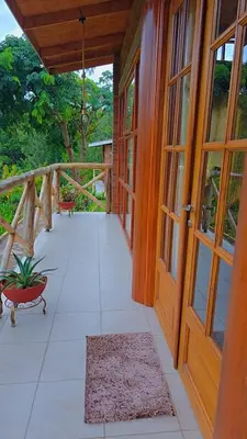 an empty porch with a wooden door and a rug at Daima Escape in Usa River