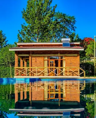 a house on a lake with its reflection in the water at Daima Escape in Usa River