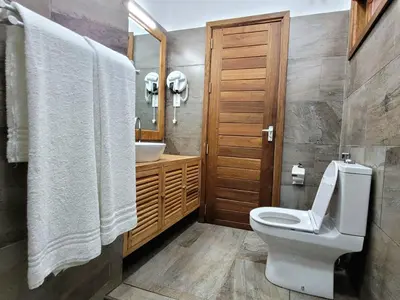 a bathroom with a toilet and a sink at Babylon Lodge in Marangu