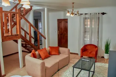 a living room with a couch and a staircase at Fusion of Style & Comfort in Arusha