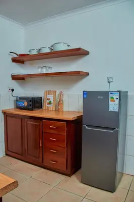 a kitchen with a counter and a refrigerator in it at Fusion of Style & Comfort in Arusha