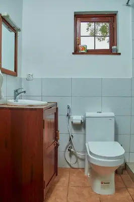 a bathroom with a toilet and a sink and a window at Fusion of Style & Comfort in Arusha