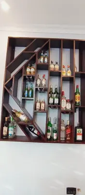 a shelf filled with lots of bottles of alcohol at Elwood Lodge in Arusha