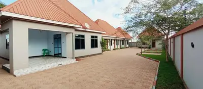 a row of white buildings with a driveway at Elwood Lodge in Arusha