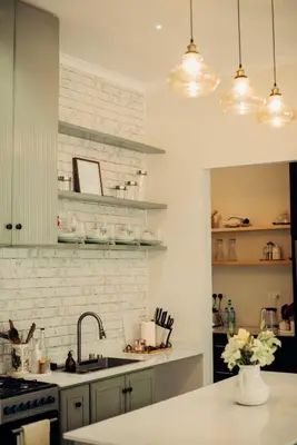 a kitchen with white brick walls and a sink at Garden Villa by Wedelia Homes in Tengeru