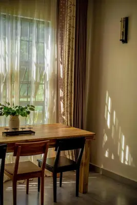 a dining room table with two chairs and a window at Garden Villa by Wedelia Homes in Tengeru