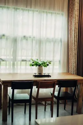 a wooden table with chairs and a potted plant on top at Garden Villa by Wedelia Homes in Tengeru