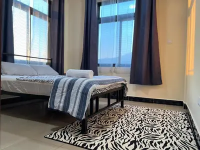 a bedroom with a bed and a zebra rug at Tai Africa Apartment in Arusha