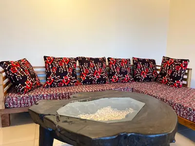 a couch with pillows and a table in a living room at Tai Africa Apartment in Arusha
