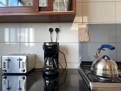 a kitchen counter with a blender and a tea kettle at Tai Africa Apartment in Arusha