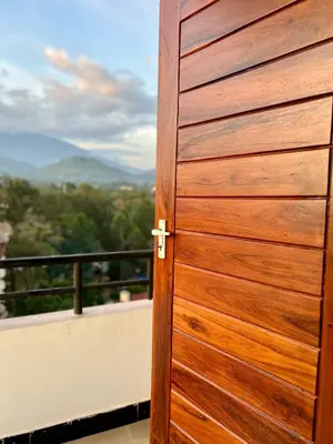 a wooden door on a balcony with a view at Tai Africa Rooms in Arusha