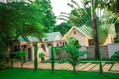 a house with trees in front of it at Nguchiro Palace Hotel in Moshi