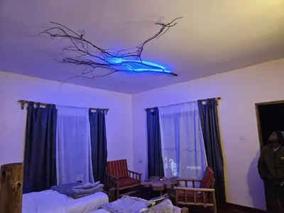 a person standing in a room with a blue light on a ceiling at African Royal Villa and Campsite in Karatu