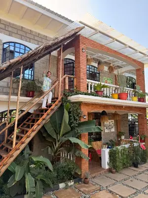 a woman sitting on the stairs of a house at Serengeti Home in Arusha