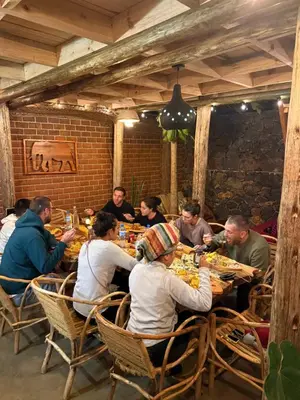 a group of people sitting at a table eating food at Serengeti Home in Arusha
