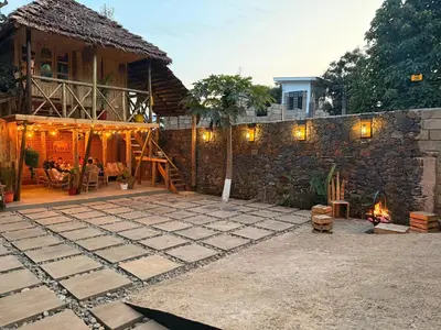 a house with a stone wall and a patio at Serengeti Home in Arusha