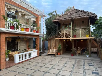 an outdoor patio with a house with a thatch roof at Serengeti Home in Arusha