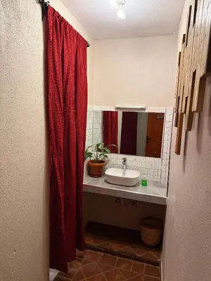 a bathroom with a sink and a red shower curtain at Serengeti Home in Arusha