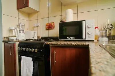 a kitchen with a microwave sitting on top of a stove at Bluezone Residence in Arusha
