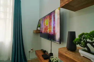 a living room with a flat screen tv on the wall at Bluezone Residence in Arusha