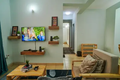 a living room with a flat screen tv on the wall at Bluezone Residence in Arusha