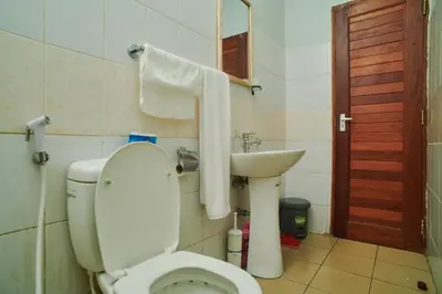 a bathroom with a toilet and a sink at Bluezone Residence in Arusha
