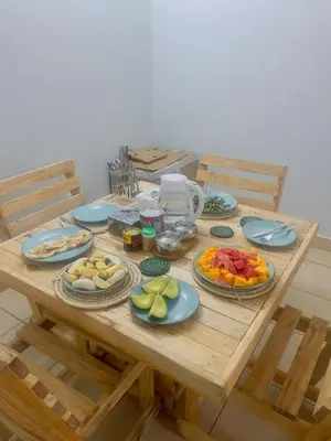 a wooden table with plates of fruit on it at Bluezone Residence in Arusha