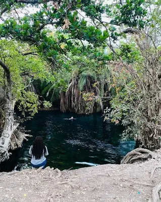 a person sitting in the water near a river at Boma villa kilimanjaro in Boma la Ngombe