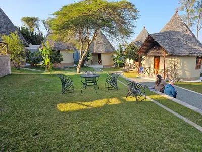 a group of chairs and a table in a yard at Oiti Boma Lodge Arusha in Arusha