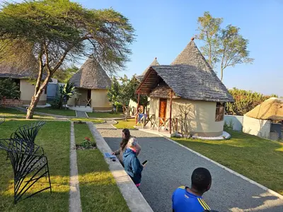 a group of people standing in front of a house at Oiti Boma Lodge Arusha in Arusha