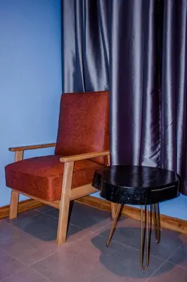 a chair and a table in front of a curtain at Avocado Kilimanjaro Homes in Marangu