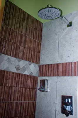 a bathroom with a shower with brown tiles at Avocado Kilimanjaro Homes in Marangu