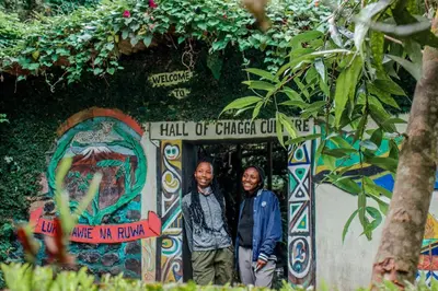 two men are standing in front of a sign at Avocado Kilimanjaro Homes in Marangu