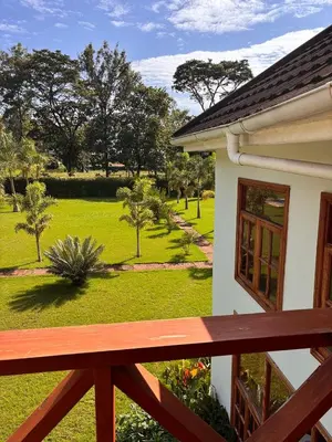 a balcony of a house with a view of a park at Arusha Farm House in Arusha