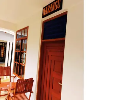 a door to a restaurant with a sign above it at Hellens Riverside Villa Luxury Garden Room in Msaranga