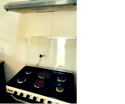 a kitchen with a stove top oven in a kitchen at Hellens Riverside Villa Luxury Garden Room in Msaranga