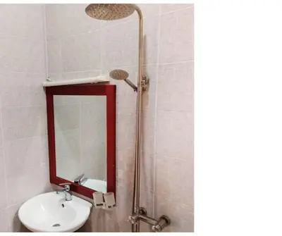 a bathroom with a sink and a mirror at Hellens Riverside Villa Luxury Garden Room in Msaranga