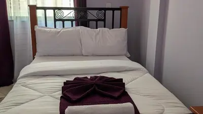 a white bed with a bow on top of it at Kilimanjaro Helichrysum Homes in Arusha