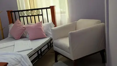 a living room with a couch and a chair at Kilimanjaro Helichrysum Homes in Arusha