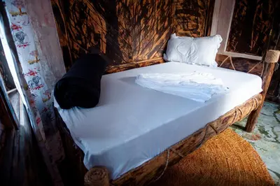 a bed with white sheets and pillows on it at Langalanga Eco Farm in Nkoanrua