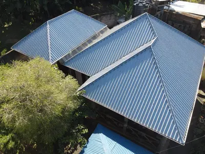 three blue roofs on top of a building with trees at Langalanga Eco Farm in Nkoanrua