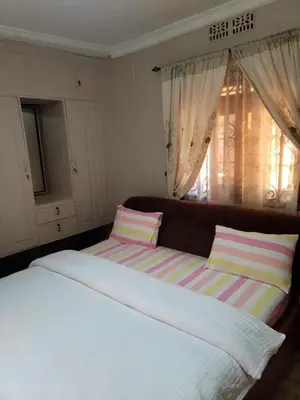 a bedroom with a large bed and a window at Cape Haven in Arusha