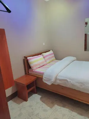 a small bedroom with a bed and a night stand at Cape Haven in Arusha