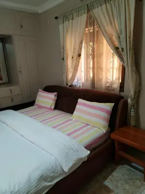 a couch with two pillows on it in a bedroom at Cape Haven in Arusha