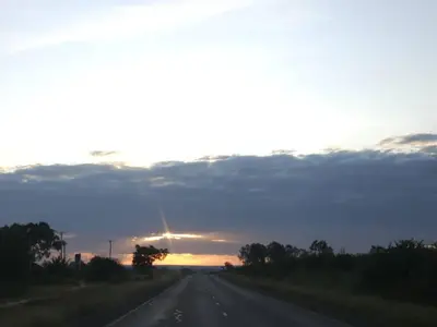 an empty road with the sunset in the background at West Kilimantis in Bondeni Boloti