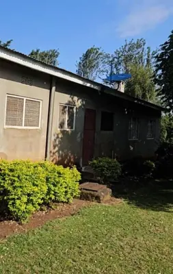 a house with a red door in a yard at West Kilimantis in Bondeni Boloti